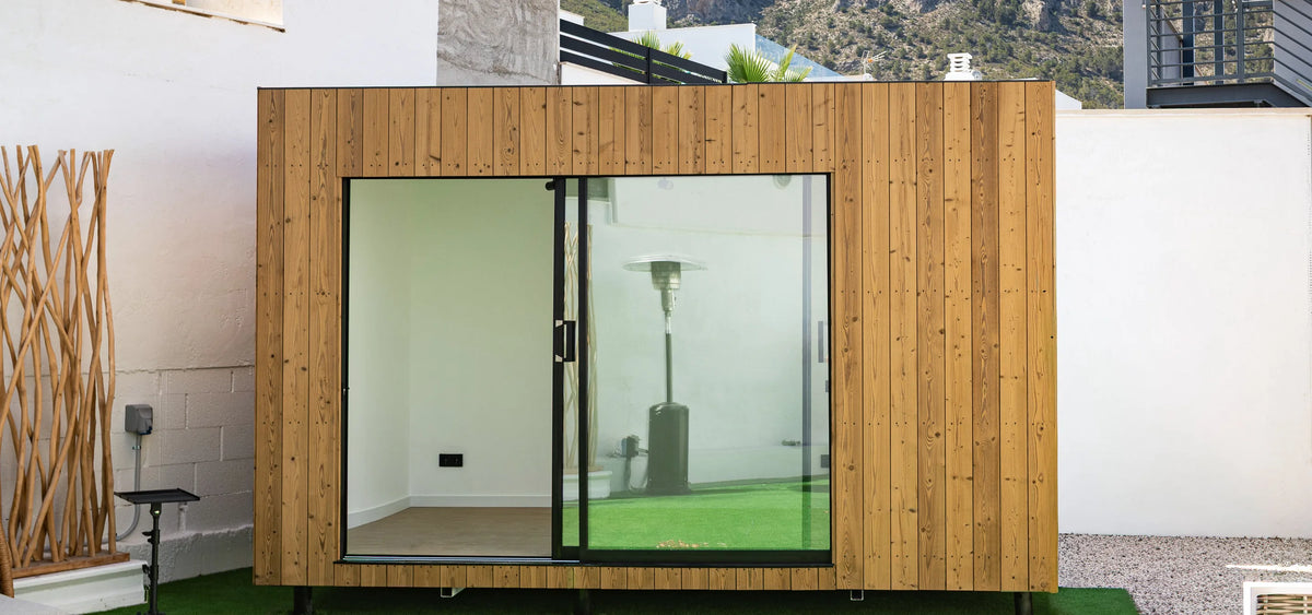 An oak NOOK 10 seen head-on in its garden, with the mountains behind